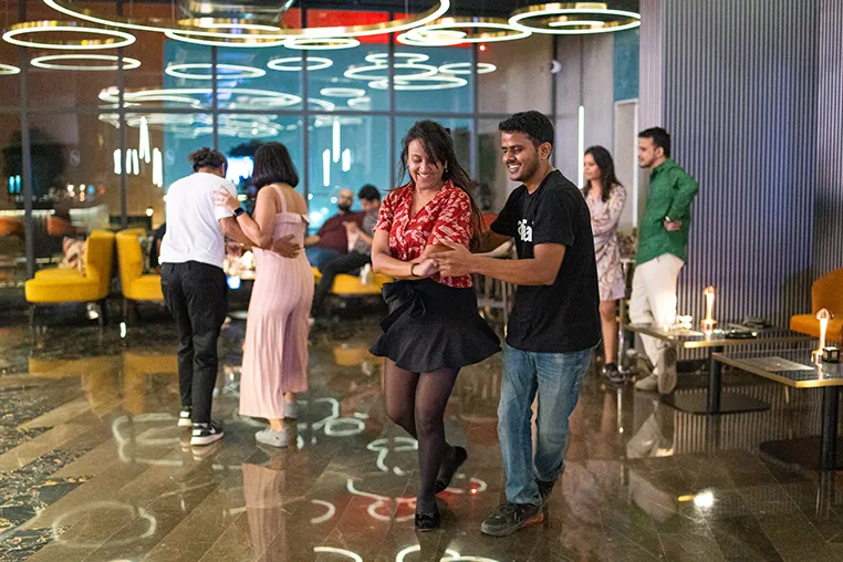 A couple doing a partner dance with the mans arms wrapped around the woman